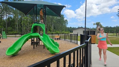 Mom running around the playground while kids play to keep active